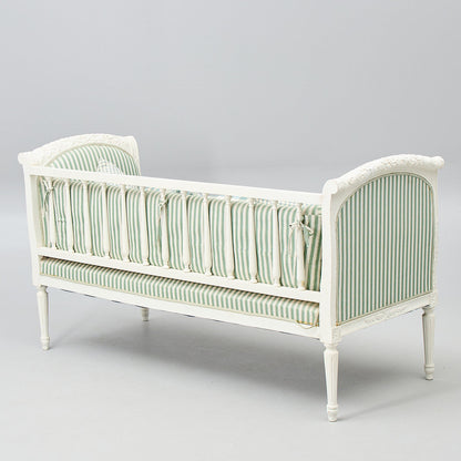 Back view of Gustavian-style painted banquette sofa with green striped cushions