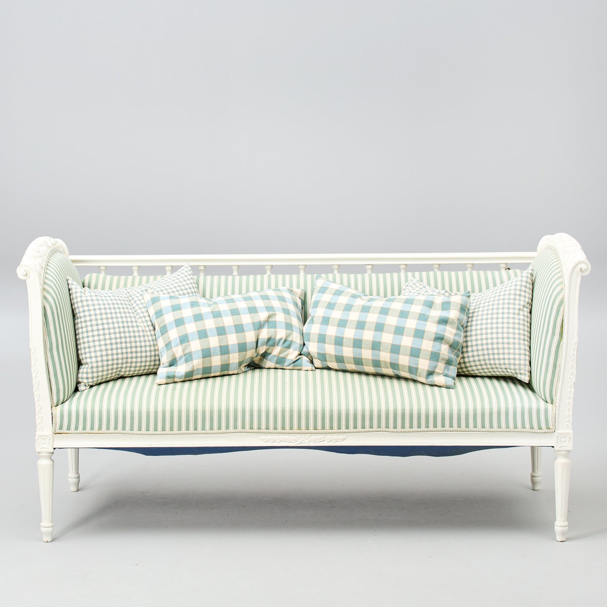 Gustavian-style painted banquette sofa with green striped upholstery front view
