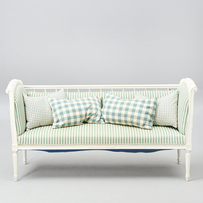 Gustavian-style painted banquette sofa with green striped upholstery front view