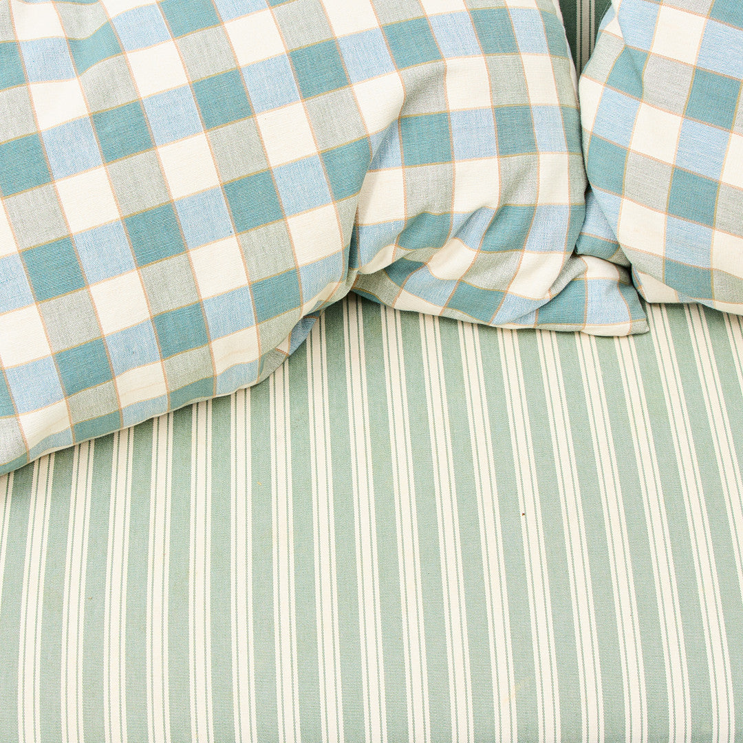 Detail of green striped and check upholstery on Gustavian-style banquette sofa