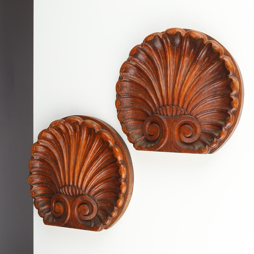 Pair of Danish carved oak scallop shell ornaments displayed on wall