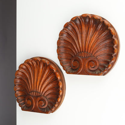 Pair of Danish carved oak scallop shell ornaments displayed on wall